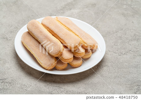 Italian Savoiardi ladyfingers Biscuits in plate on concrete backgound Italian Savoiardi ladyfingers Biscuits in plate on concrete backgound 48418750