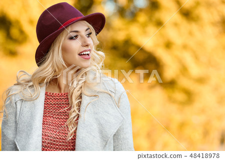 Beautiful elegant woman standing in autumn park Beautiful elegant woman standing in autumn park 48418978