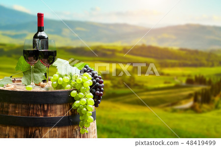 Red wine bottle and wine glass on wodden barrel Red wine bottle and wine glass on wodden barrel 48419499