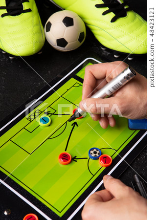 Photo of table football, soccer ball, boots, human hands with marker Photo of table football, soccer ball, boots, human hands with marker 48423121