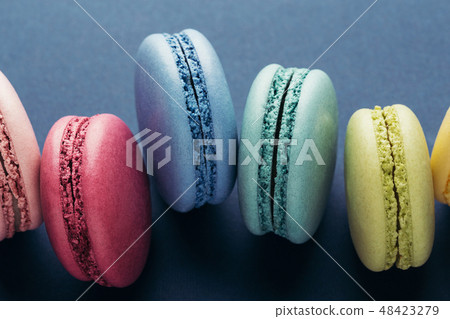 Colorful macarons on dark blue background. 48423279