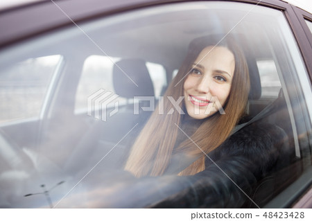 Young lady driving a car in winter Young lady driving a car in winter 48423428