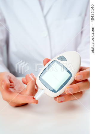Image of doctor's hand with glucometer. Image of doctor's hand with glucometer. 48425140
