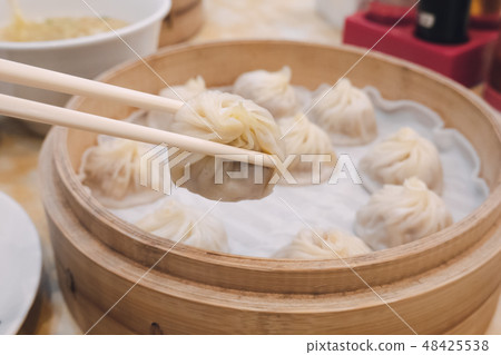 Xiao long bao soup dumpling buns with chopsticks  48425538
