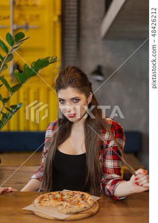 Beautiful and sexy girl sitting at a table with a 48426212
