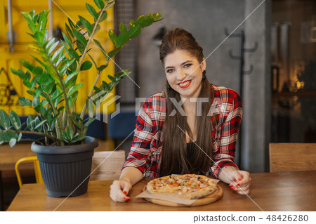Beautiful and sexy girl sitting at a table with a Beautiful and sexy girl sitting at a table with a 48426280