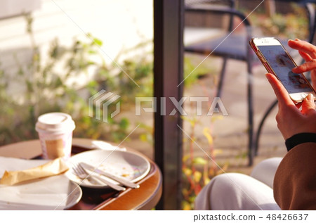 A woman who operates a smartphone A woman who operates a smartphone 48426637