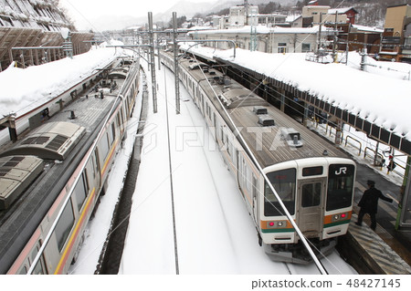The Joetsu Line 211 which is stopping at Wataru Suidobashi Station in winter The Joetsu Line 211 which is stopping at Wataru Suidobashi Station in winter 48427145