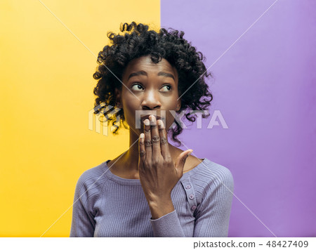 The young woman whispering a secret behind her hand The young woman whispering a secret behind her hand 48427409