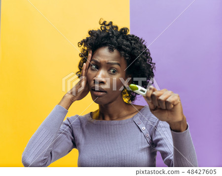 young woman looking on pregnancy test young woman looking on pregnancy test 48427605