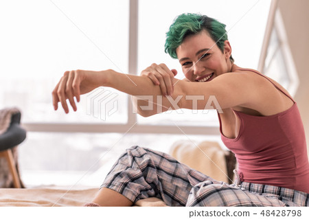 Woman wearing pajama trousers and camisole feeling energized Woman wearing pajama trousers and camisole feeling energized 48428798