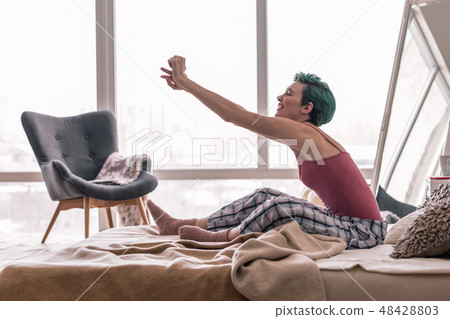 Happy woman stretching her body while waking up in the morning Happy woman stretching her body while waking up in the morning 48428803