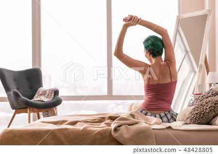 Green-haired woman in pajamas waking up in the morning 48428805