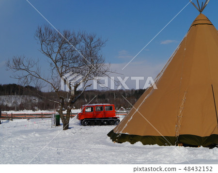 Large tent and snowmobile built in the snowy field 48432152