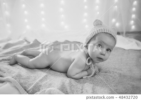 newborn baby lies in a beautiful hat newborn baby lies in a beautiful hat 48432720