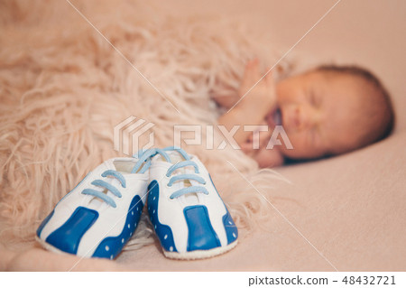 Newborn baby and a pair of baby shoes Newborn baby and a pair of baby shoes 48432721