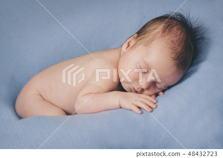 naked newborn baby sleeping curled up in a ball 48432723