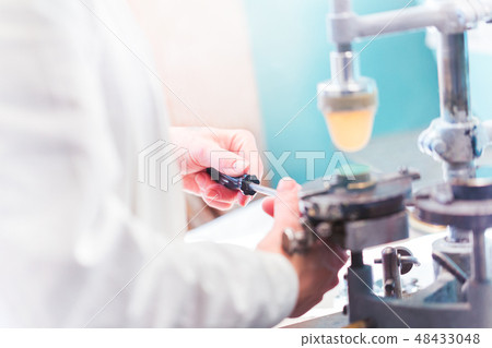 Female hand with screwdriver at industrial works 48433048