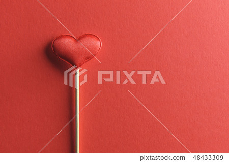 Red textile heart on wooden stick closeup 48433309
