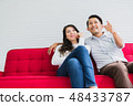 asian husband and causasian wife watch tv 48433787