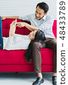 asian husband and causasian wife watch tv  48433789