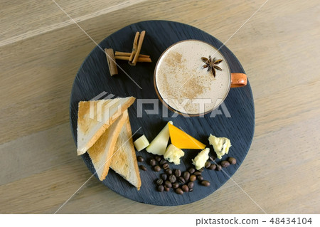 Cheese coffee with melted cheese, pieces of cheese and bread toasts on a tray. Top view. Cheese coffee with melted cheese, pieces of cheese and bread toasts on a tray. Top view. 48434104