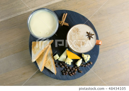 Cheese coffee with melted cheese, pieces of cheese and bread toasts on a tray. Top view. Cheese coffee with melted cheese, pieces of cheese and bread toasts on a tray. Top view. 48434105