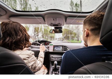 couple sitting on the front passenger driving a car couple sitting on the front passenger driving a car 48434106