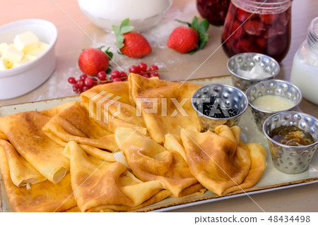 Russian traditional pancakes, blini. Served with jams, sour cream, milk and strawberry on the plate Russian traditional pancakes, blini. Served with jams, sour cream, milk and strawberry on the plate 48434498