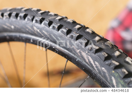 Mountain bike tire tread closeup at home workshop 48434618