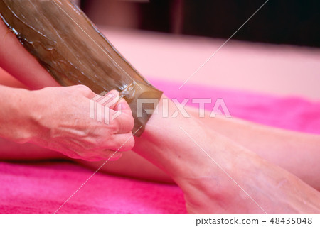 Beautician waxing woman legs, depilation in beauty Spa. Beautician waxing woman legs, depilation in beauty Spa. 48435048