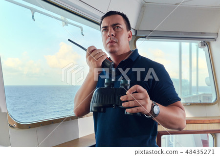 Portrait of navigator pilot officer on the bridge of the vessel Portrait of navigator pilot officer on the bridge of the vessel 48435271