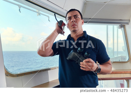 Portrait of navigator pilot officer on the bridge of the vessel Portrait of navigator pilot officer on the bridge of the vessel 48435273