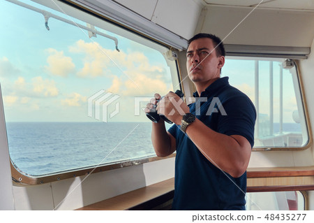Portrait of navigator pilot officer on the bridge of the vessel Portrait of navigator pilot officer on the bridge of the vessel 48435277