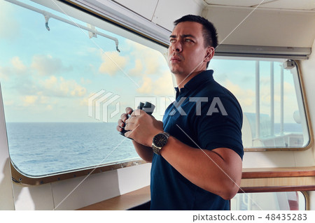 Portrait of navigator pilot officer on the bridge of the vessel Portrait of navigator pilot officer on the bridge of the vessel 48435283
