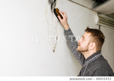 Bearded man removes black mold  after leakage 48435433