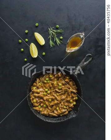 Asian beef thin slices with green peas in curry. Asian beef thin slices with green peas in curry. 48435756