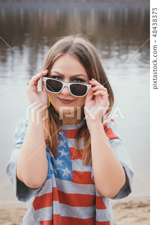 A girl hippy on the river bank posing and smiling A girl hippy on the river bank posing and smiling 48438375