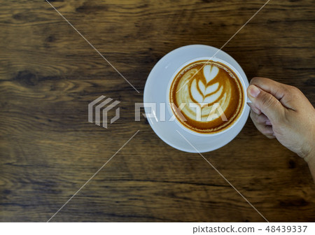 Hand Holding Coffee Cup On Table Hand Holding Coffee Cup On Table 48439337
