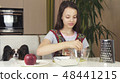 Teen girl with dog Papillon prepare cookies, knead the dough 48441215