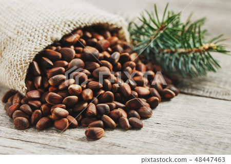 Pine nuts in a bag of burlap on an old vintage Pine nuts in a bag of burlap on an old vintage 48447463