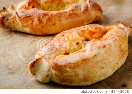 two appetizing khachapuri on parchment for baking two appetizing khachapuri on parchment for baking 48448638