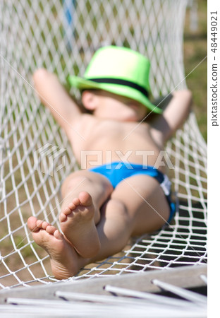 happy boy sleeps in hammock at garden happy boy sleeps in hammock at garden 48449021
