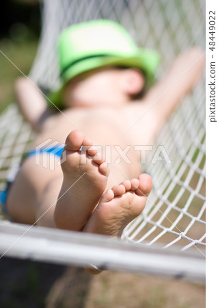 happy boy sleeps in hammock at garden happy boy sleeps in hammock at garden 48449022