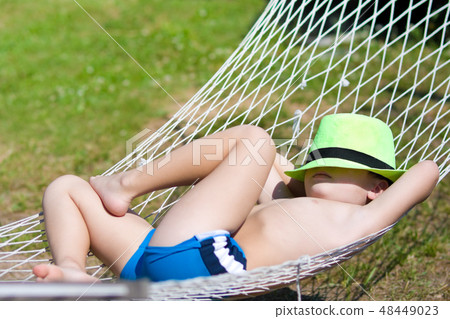 happy boy sleeps in hammock at garden happy boy sleeps in hammock at garden 48449023