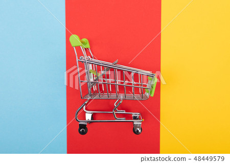 self-service supermarket trolley cart with green handle on colorful background 48449579