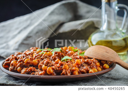 Chile with pork and chickpeas on a plate 48450265