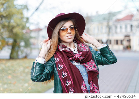 woman with a hat, sunglasses and jacket on a b 48450534