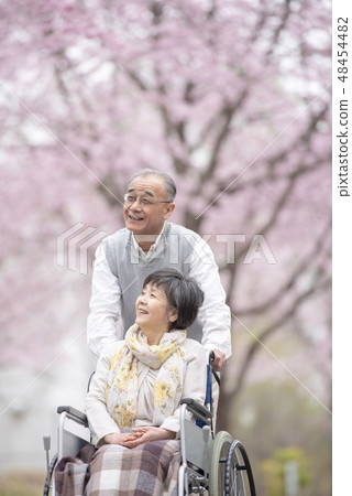 Senior couple walking in a wheelchair 48454482