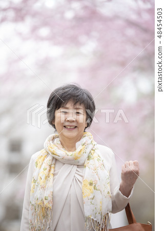 Senior woman smiling in cherry blossoms 48454503